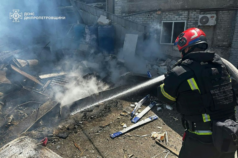 Photo prise et diffusée le 24 juin 2025 par le Service d'urgence de l'État ukrainien d'un pompier éteignant un incendie après une frappe de missile russe à Dnipro, dans l'est de l'Ukraine ( State Emergency Service of Ukraine / Handout )