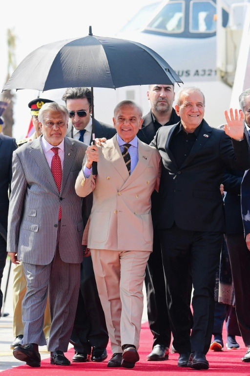 Photo diffusée et prise par le bureau du Premier ministre pakistanais le 23 juin 2026, montrant le Premier ministre pakistanais, Shehbaz Sharif (ac), le ministre pakistanais des Affaires étrangères, Ishaq Dar (g) aux côtés du président iranien, Massoud Pezeshkian (d), à son arrivée à la base aérienne Nur Khan de Rawalpind, au Pakistan ( Pakistan Prime Minister's Office / - )