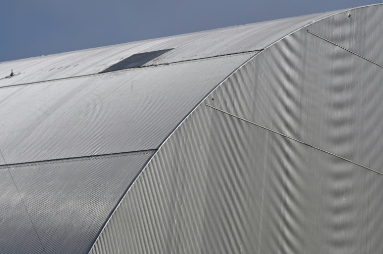 Un "patch" posé sur une partie de la nouvelle enceinte de confinement, endommagée le 14 février 2025 par une attaque de drone russe, au-dessus du réacteur 4 détruit de la centrale nucléaire de Tchernobyl, le 23 avril 2026 ( AFP / Sergei SUPINSKY )