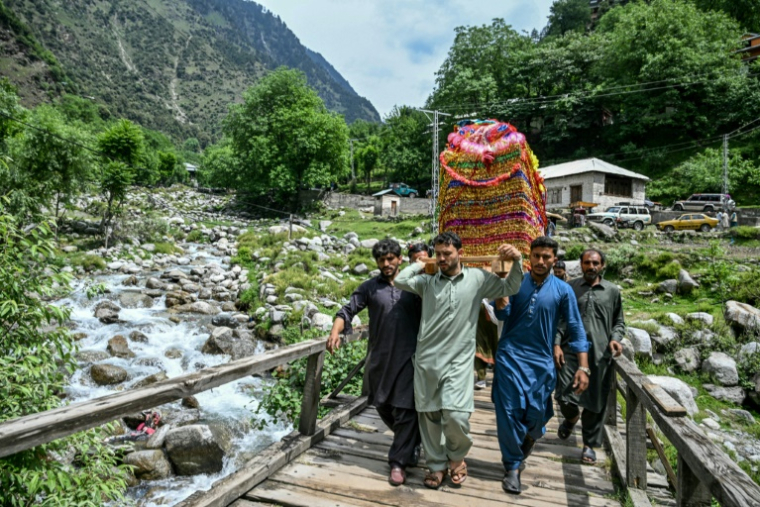 Des proches portent la mariée, Rabia Bibi, dans un palanquin traditionnel, vers la maison de son époux dans le village d'Ashkot, dans la région du Cachemire administrée par le Pakistan, le 3 mai 2025 ( AFP / Farooq NAEEM )