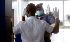 Un agent de sécurité portant un masque et des gants, fouille un passager à l'aéroport international Murtala Muhammed de Lagos, le 11 août 2014, après que le gouvernement a confirmé un nouveau cas d'Ebola dans la capitale économique du Nigeria, le 6 août 2014 ( AFP / PIUS UTOMI EKPEI )