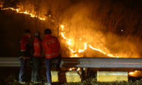 Des agents du Service des forêts sud-coréen observent les graves incendies qui ont ravagé le sud-est du pays, le 27 mars 2025 à Andong ( AFP / ANTHONY WALLACE )
