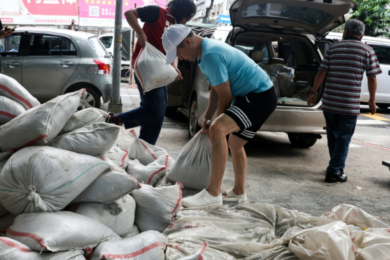 Des habitants installent des sacs de sable pour se protéger du typhon Bavi, le 9 juillet 2026 à Taipei, sur l'île de Taïwan ( AFP / I-Hwa Cheng )