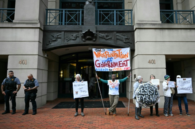 Des manifestants protestent contre l'inculpation de l'ancien directeur du FBI, la police fédérale américaine, James Comey, devant le tribunal fédéral d'Alexandria, aux Etats-Unis, le 8 octobre 2025 ( AFP / ANDREW CABALLERO-REYNOLDS )