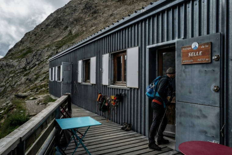 Un randonneur entre dans le refuge de la Selle, dans le massif des Ecrins, à Saint-Christophe-en-Oisans, le 8 juillet 2025 en Isère ( AFP / JEFF PACHOUD )