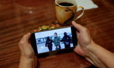 Une personne regarde sur un smartphone un fil d'actualité diffusant des images du FSB russe montrant l'opération d'interpellation d'un journaliste japonais accusé d'espionnage, à Moscou, le 13 octobre 2026 ( AFP / Tatyana MAKEYEVA )