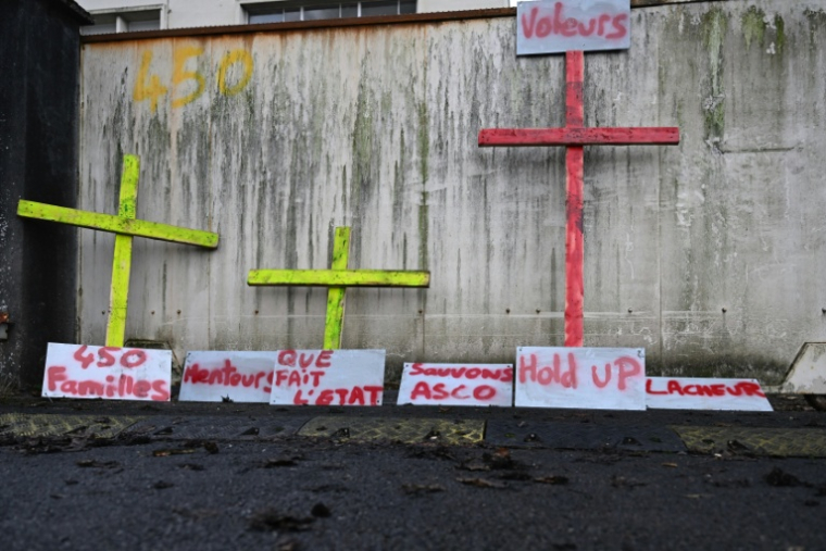 Des croix et des pancartes sur lesquelles on peut lire "Menteurs", "Que fait l'Etat" ou "Voleurs" sont installées devant l'usine de Novasco à Hagondange (Moselle), le 14 novembre 2025 ( AFP / Jean-Christophe VERHAEGEN )