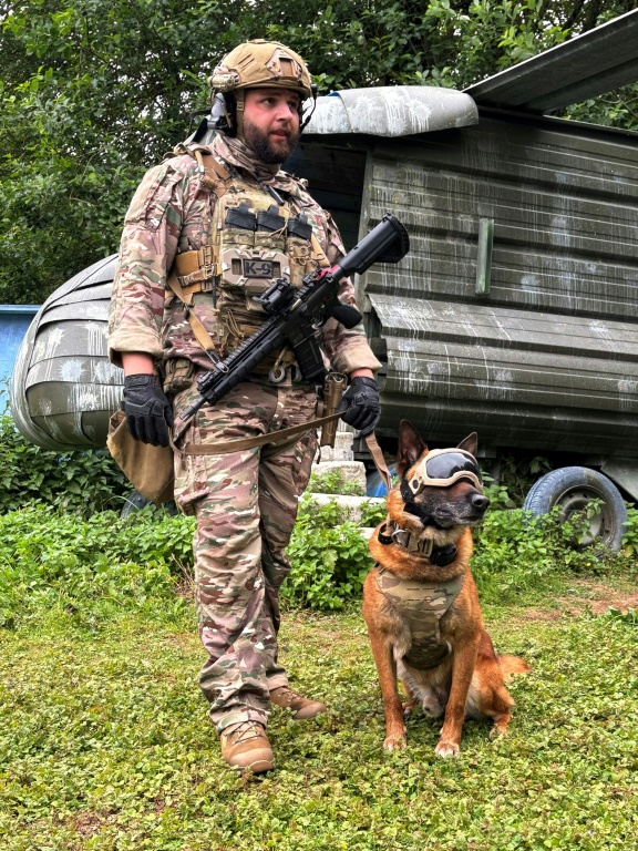 Le sergent-chef Dorian, du Commando parachutiste de l'Air 20 (CPA20) et Peyo, un berger belge malinois, lors d’une démonstration sur la base aérienne de Vélizy-Villacoublay, le 28 mai 2025 dans les Yvelines ( AFP / Mathieu RABECHAULT )