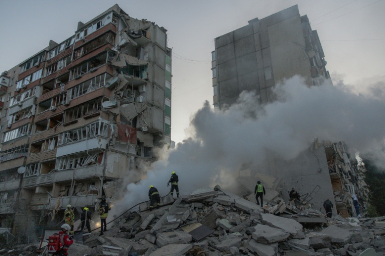 Des secouristes s'affairent dans un immeuble résidentiel partiellement détruit après des frappes de drones et de missiles russes sur Kiev, la capitale ukrainienne, le 14 mai 2026 ( AFP / Roman PILIPEY )