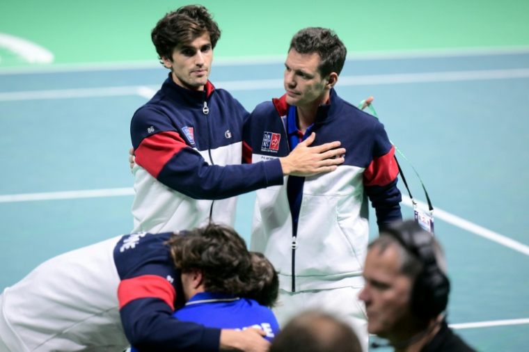 Le clan français dépité (ici le capitaine Paul-Henri Mathieu (à dr.) réconfortant Pierre-Hugues Herbert après la défaite devant la Belgique à Bologne, le 18 novembre 2025  ( AFP / Tiziana FABI )