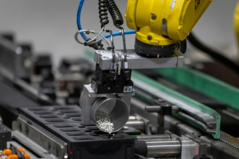 Un bras robotisé dose des granulés d’argent pour fusionner de petits lingots d'argent dans la fonderie de Głogow, en Pologne, le 24 mars 2026 ( AFP / Wojtek RADWANSKI )