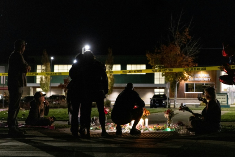 Des personnes devant un mémorial improvisé aux abords de l’école primaire Silver Rail, après une fusillade à Bend, le 15 octobre 2026 dans l'Oregon ( AFP / Payton Bruni )