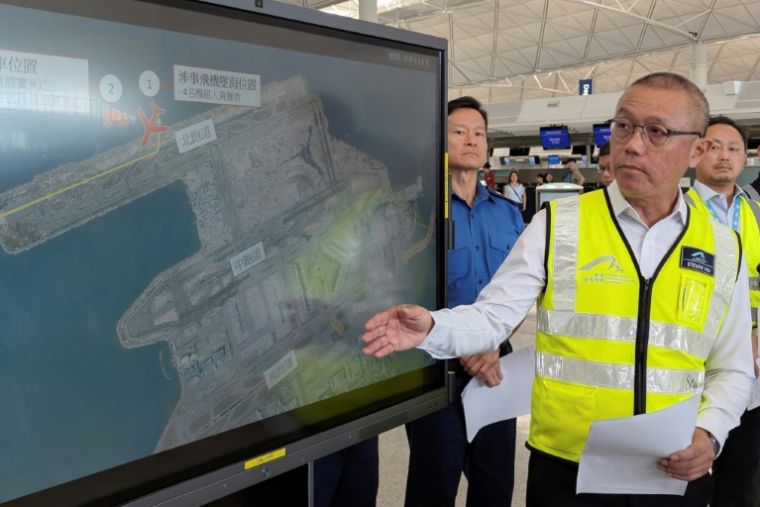Steven Yiu, directeur exécutif des opérations aéroportuaires de l'Autorité aéroportuaire de Hong Kong, montre sur un écran l'endroit où un avion cargo Boeing a dérapé dans la mer après avoir heurté un véhicule au sol lors de son atterrissage sur la piste nord de l'aéroport de Hong Kong, le 20 octobre 2025 ( AFP / Holmes CHAN )