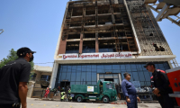 Opération de nettoyage devant le bâtiment du centre commercial Hyper Mall ravagé par un incendie dans la nuit tuant plus de 60 personnes, le 17 juillet 2025 à Kut, dans l'est de l'Irak ( AFP / AHMAD AL-RUBAYE )