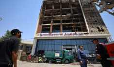 Opération de nettoyage devant le bâtiment du centre commercial Hyper Mall ravagé par un incendie dans la nuit tuant plus de 60 personnes, le 17 juillet 2025 à Kut, dans l'est de l'Irak ( AFP / AHMAD AL-RUBAYE )