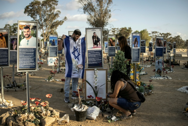 Des membres de la famille d'une victime de l'attaque du Hamas le 7 octobre 2023 nettoient et décorent leur mémorial, sur le site du festival Nova, à Réïm, dans le sud d'Israël, le 6 octobre 2025 ( AFP / JOHN WESSELS )