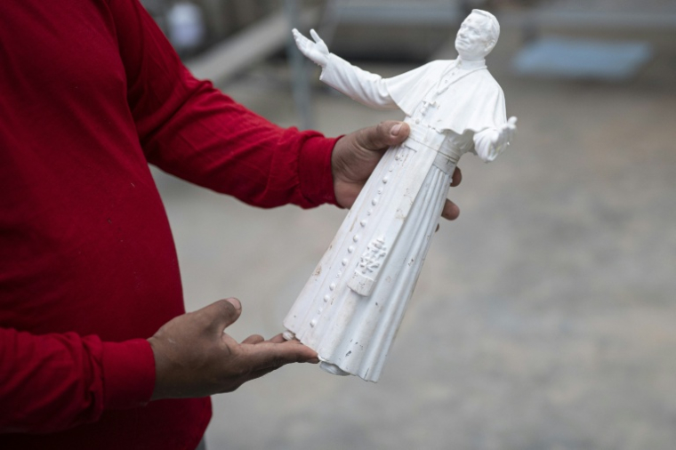 Rafael Gutierrez, 42 ans, sculpteur diplômé de l'École des beaux-arts du Pérou, tient une maquette de la statue du pape Léon XIV dans son atelier du district de Carabayllo, dans la périphérie nord de Lima, le 25 septembre 2026 ( AFP / ERNESTO BENAVIDES )