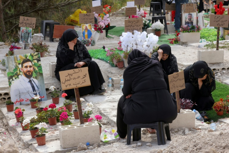 Des personnes déplacées se recueillent devant les tombes de leurs proches tués pendant le conflit avec Israël, le 27 mai 2026 près de Saïda, dans le sud du Liban ( AFP / MAHMOUD ZAYYAT )
