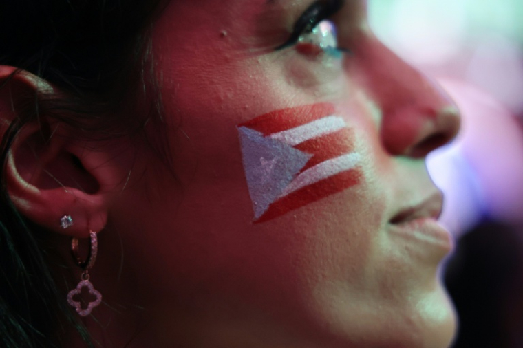 Une fan regarde la retransmission du spectacle de Bad Bunny, le 8 février 2026 à San Juan, à Porto Rico ( AFP / Jaydee Lee SERRANO )