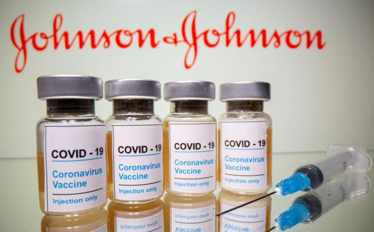 Des flacons et une seringue médicale devant le logo de J&J