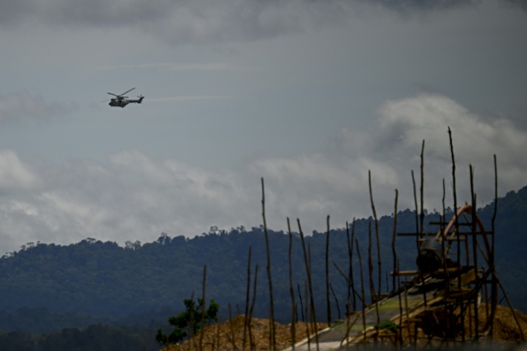 Un hélicoptère de l'armée vénézuélienne survole une mine d'or artisanale à Las Brisas de Cuyuni, le 11 juin 2026 ( AFP / Federico PARRA )
