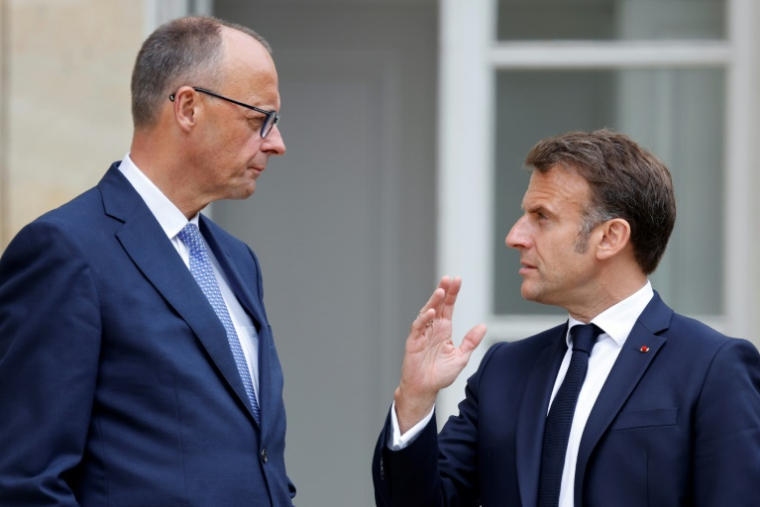 Le président français Emmanuel Macron (d) s'entretient avec le chancelier allemand Friedrich Merz dans le jardin du palais de l'Elysée à Paris, le 7 mai 2025 ( POOL / Ludovic MARIN )