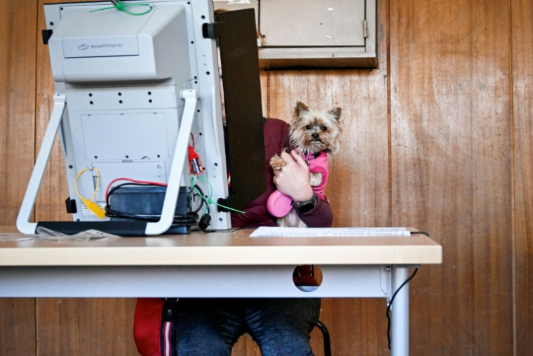 Une électrice vote en compagnie de son chien, le 19 avril 2026 à Sofia ( AFP / Dimitar KYOSEMARLIEV )