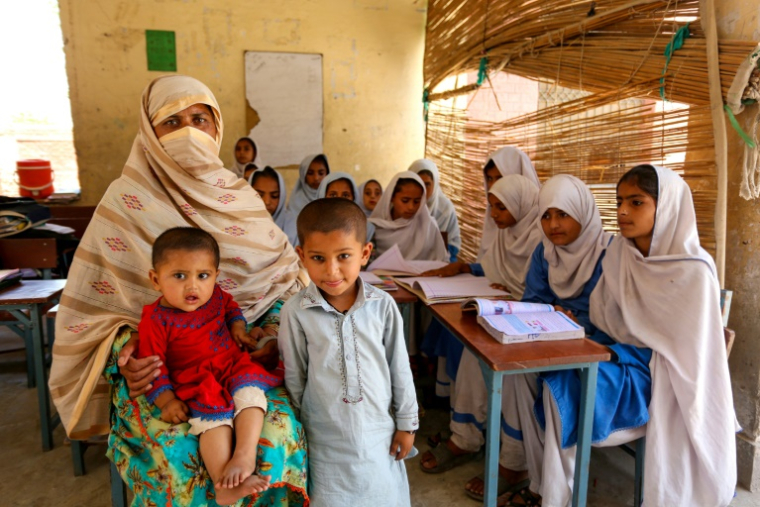 L'enseignante Nazia Hussain (d), et ses enfants et élèves dans une école publique du district de Rajanpur, dans la province du sud-ouest du Pendjab, le 15 mai 2025 au Pakistan ( AFP / Shahid Saeed MIRZA )