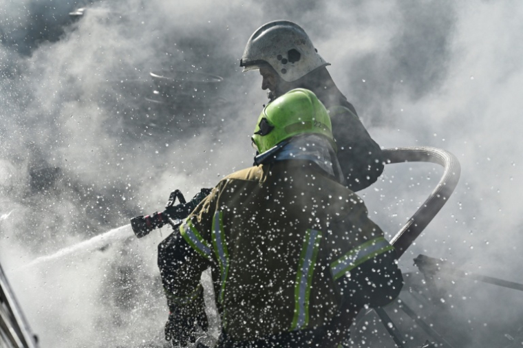 Des pompiers sur les lieux d'un incendie après une attaque de missile et de drone dans la localité ukrainienne de Brovary, près de Kiev, le 14 mars 2026   ( AFP / Genya SAVILOV )