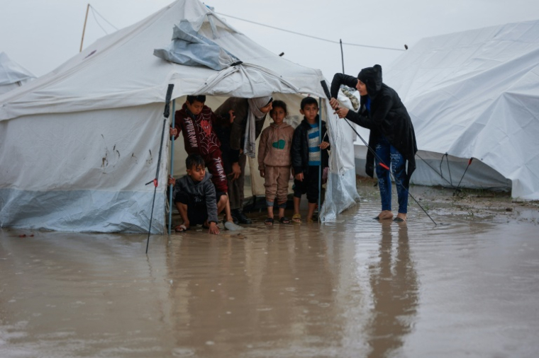 Des enfants sous une tente dans un camp du quartier de Zeitoun, à Gaza-ville, inondé après le passage de la tempête Byron, le 11 octobre 2025 ( AFP / Omar AL-QATTAA )