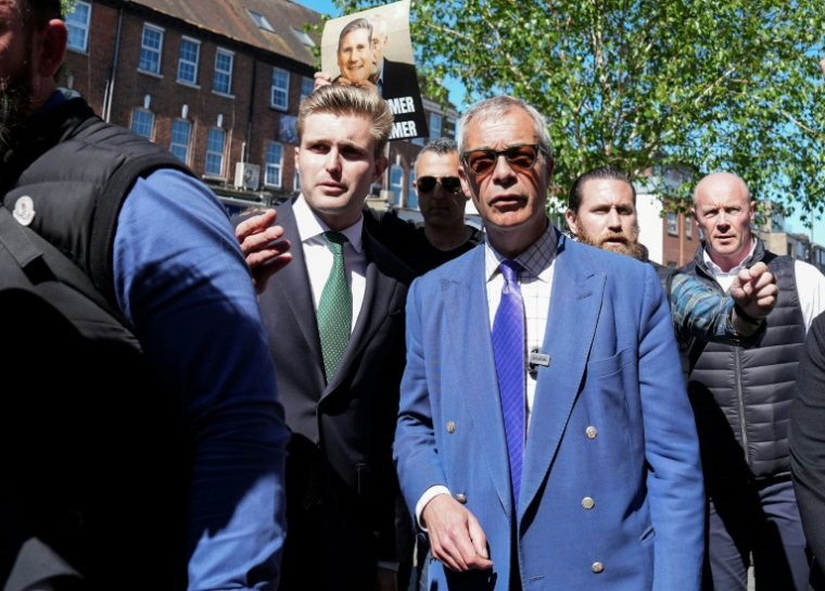 Nigel Farage (C) parle avec Dan Jukes (G) dans le nord de Londres le 30 avril 2026 ( AFP / CARLOS JASSO )