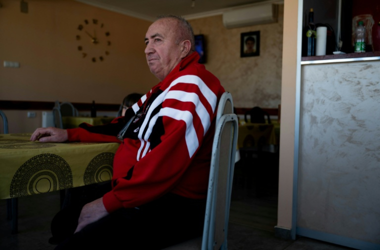 Jovan Zivic est assis dans le petit café qu'il tient dans le village de Plemetina, près d'une centrale thermique au charbon, le 8 avril 2026 au Kosovo ( AFP / Armend NIMANI )