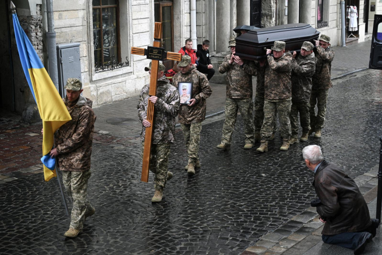 Des soldats ukrainiens transportent le cercueil du militaire ukrainien Volodymyr Levkiv lors d'une cérémonie funéraire à Lviv (ouest de l'Ukraine) le 15 mai 2025. ( AFP / YURIY DYACHYSHYN )