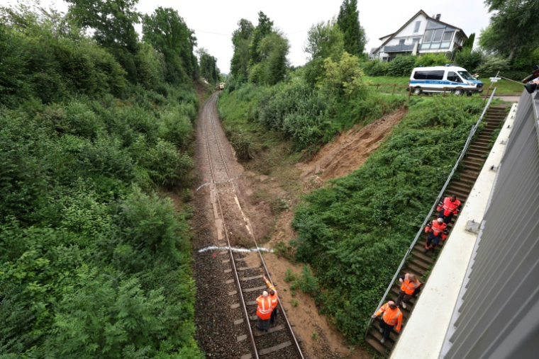 Des cheminots inspectent la voie ferrée devant un train déraillé près de Riedlingen, près de Biberach an der Riss, dans le sud-ouest de l'Allemagne, le 28 juillet 2025, au lendemain d'un accident ( AFP / Karl-Josef Hildenbrand )