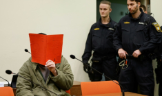 L'Afghan Farhad N. (g.), le visage caché derrière un dossier, est assis dans la salle d'audience du tribunal, le 16 janvier 2026 à Munich, pour le début de son procès pour avoir foncé en voiture dans la foule à Munich en 2025 ( AFP / Michaela Stache )