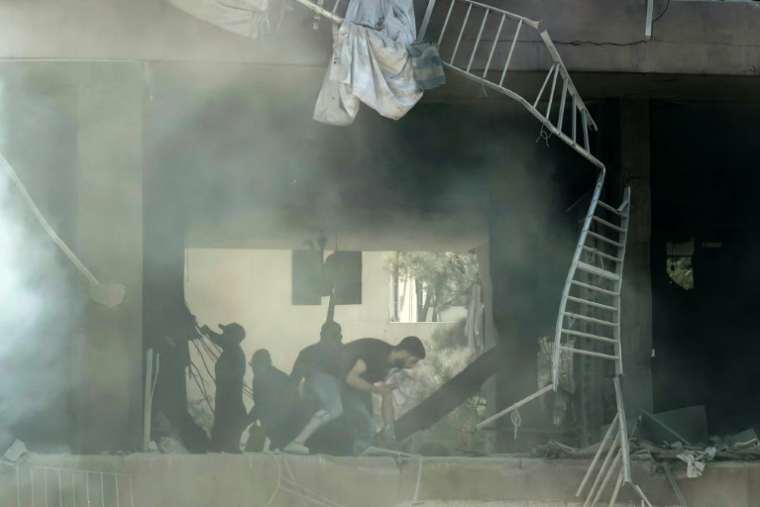 Des habitants recherchent des survivants sur le site d'une frappe aérienne israélienne qui a ciblé un bâtiment dans la banlieue sud de Beyrouth, le 14 juin 2026 au Liban ( AFP / Ibrahim AMRO )