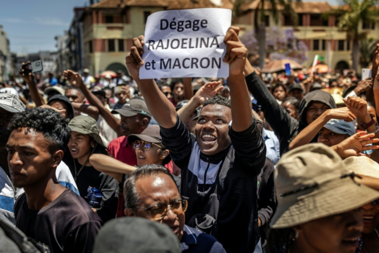 Un manifestant brandit une pancarte critique du président malgache et du président français lors d'un rassemblement à Antananarivo le 14 octobre 2025 ( AFP / Luis TATO )