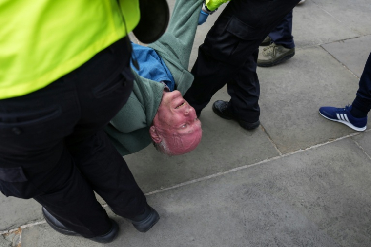La police évacue un manifestant tandis que des personnes se rassemblent pour réclamer la levée de l’interdiction visant le groupe Palestine Action lors d’une manifestation à Trafalgar Square, dans le centre de Londres, le 11 avril 2026. Le gouvernement travailliste du Premier ministre britannique Keir Starmer a interdit Palestine Action en tant qu’organisation terroriste en 2025, faisant du fait d’appartenir au groupe ou de le soutenir une infraction pénale. ( AFP / CARLOS JASSO )