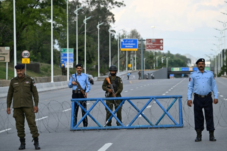 Des agents de sécurité montent la garde sur une route barrée à Islamabad, le 9 avril 2026 ( AFP / Aamir QURESHI )