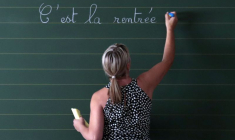 Une enseignante écrit une phrase au tableau de sa classe le premier jour de la rentrée scolaire dans une école primaire de Nice