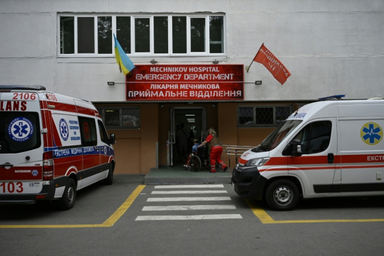 Un ambulancier, vêtu d'un gilet pare-balles, transporte une femme à l'hôpital Metchnikov de la ville de Dnipro, le 8 juin 2026, dans le cadre de l'invasion russe de l'Ukraine ( AFP / Genya SAVILOV )