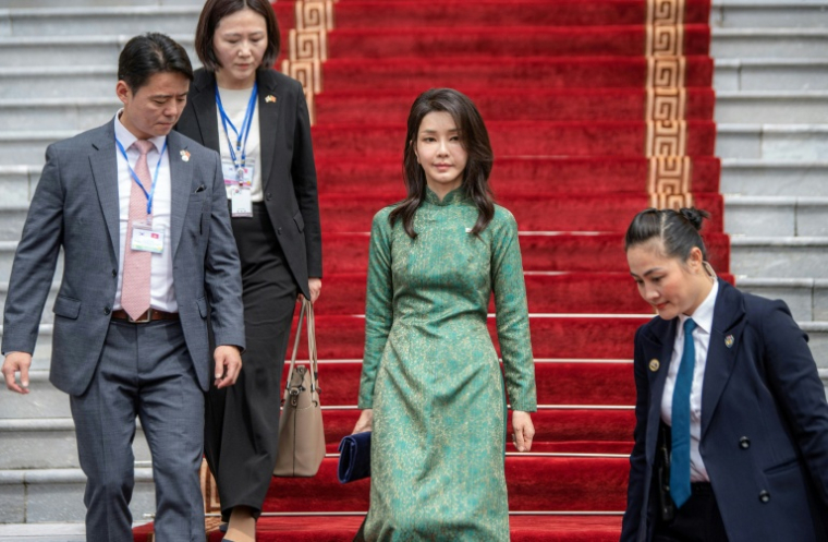 L'épouse du président sud-coréen Kim Keon-hee (au centre), vêtue d'une robe traditionnelle vietnamienne, descend les escaliers du palais présidentiel à Hanoï, le 23 juin 2023 ( AFP / Viet LINH )