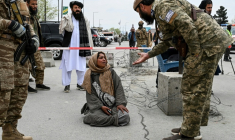 Un membre des forces de sécurité talibanes et Samira Muhammadi, lors de la deuxième cérémonie d’obsèques collectives à la mosquée Eid Gah à Kaboul, le 26 mars 2026 ( AFP / Wakil KOHSAR )