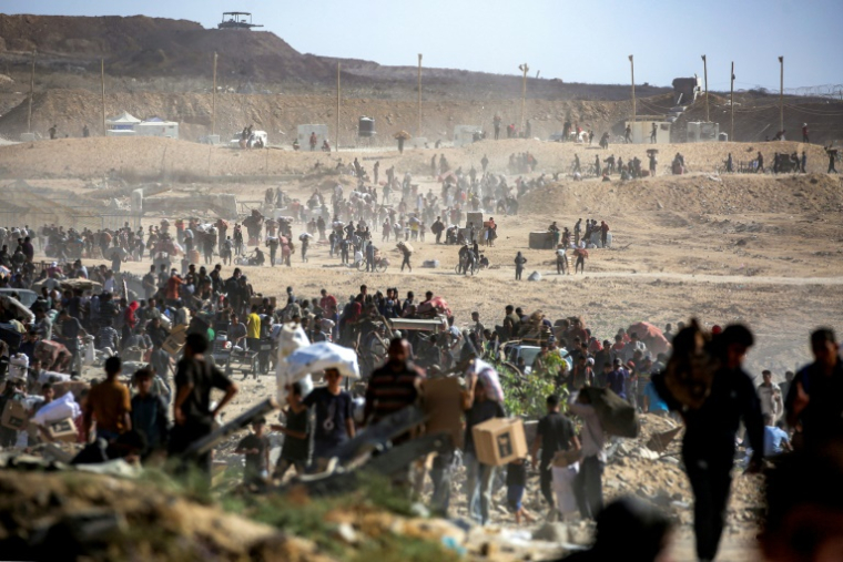 Des Palestiniens transportent des colis d'aide humanitaire reçus d'un centre de distribution géré par la Gaza Humanitarian Foundation (GHF), soutenue par les Etats-Unis et Israël, à Nousseirat, dans le centre de la bande de Gaza, le 30 septembre 2025 ( AFP / Eyad BABA )