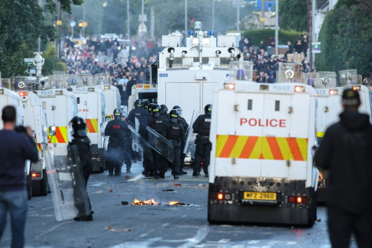 Des policiers bloquent la route aux manifestants à Glegormley, au nord de Belfast, le 10 juin 2026 en Irlande du Nord ( AFP / Paul Faith )