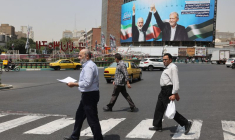 Des passants devant une photo du chef du Hamas assassiné, Ismail Haniyeh, et du président iranien, Masoud Pezeshkian, à Téhéran, en Iran