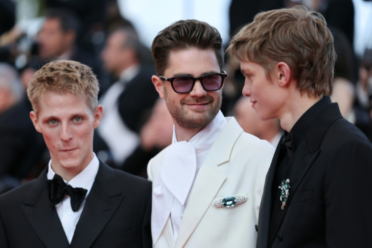 (De gauche à droite) L'acteur français Valentin Campagne, le réalisateur belge Lukas Dhont et l'acteur belge Emmanuel Macchia posent sur le tapis rouge avant la cérémonie de clôture de la 79e édition du Festival de Cannes, le 23 mai 2026 ( AFP / Thibaud MORITZ )
