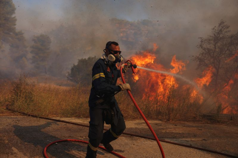 Un pompier tente d'éteindre un feu de forêt à Grammatiko, près d'Athène