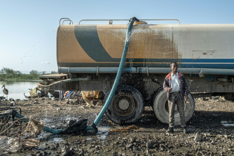 Un ouvrier à côté d'un générateur pompant de l'eau du lac Dembel pour remplir un camion-citerne pour une entreprise de construction chinoise, le 21 mai 202 à Batu, en Ethiopie ( AFP / Marco Simoncelli )