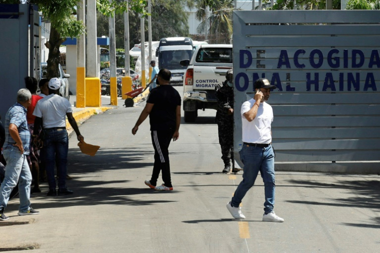 Des personnes attendent devant l'entrée du centre de détention migratoire de Haina, à Saint-Domingue, le 21 avril 2025 en République domincaine ( AFP / STRINGER )